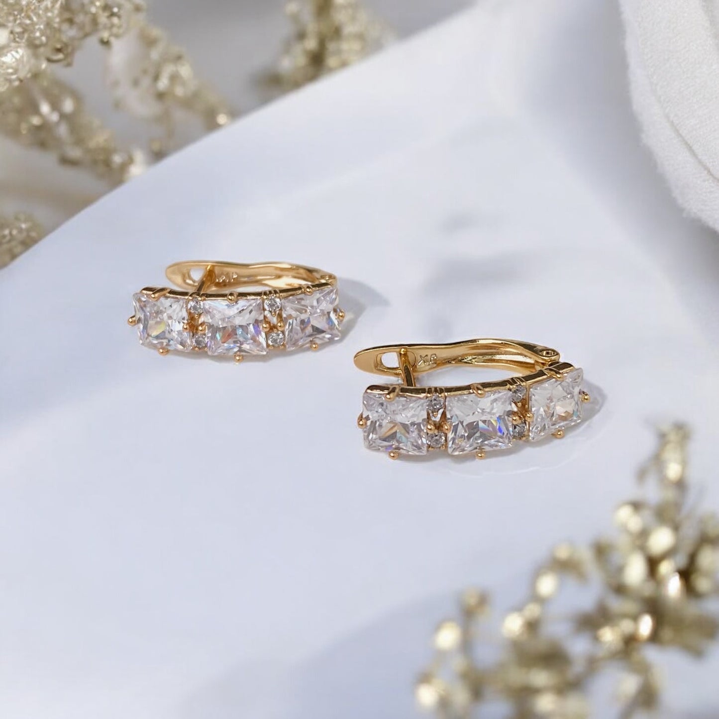 Apzeltīti auskari ar baltiem dekoratīviem kristāliem